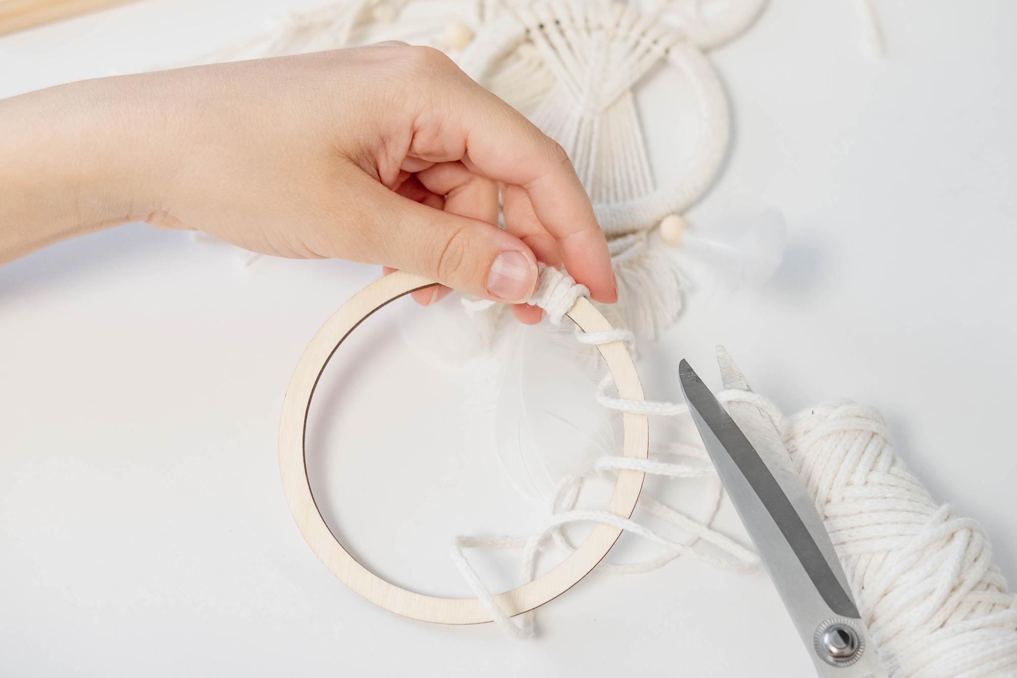 Student hands finishing a hoop with precise stitches